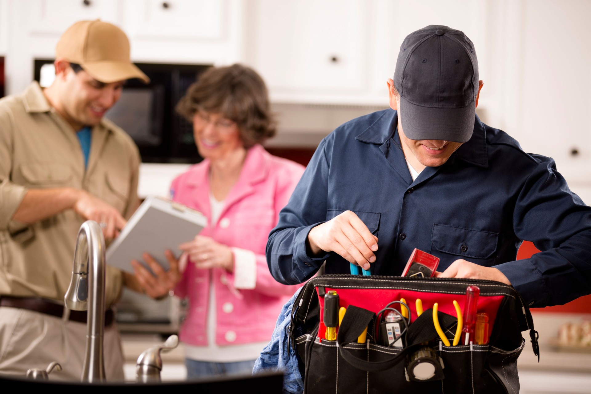 Service Industry: Two multi-ethnic repairmen work at customer's home.